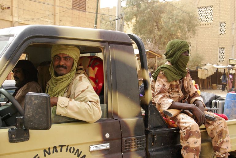 In this photo taken Saturday, April 14, 2012, Tuareg fighters from the NMLA (National Movement for the Liberation of the Azawad) sit in their vehicle, in a market in Timbuktu, Mali. West Africa's regional bloc is recommending the deployment of a regional force to Mali after Tuareg separatist rebels declared an independent state, dubbed Azawad, following a military coup last month. Regional bloc ECOWAS said Friday, April 13 that the force would help Mali secure its territory and serve as peacekeepers. (AP Photo)
