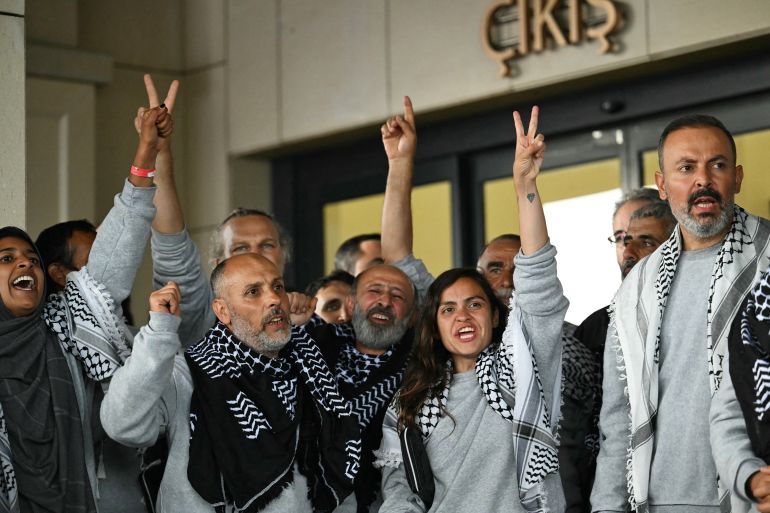 Members of the Global Sumud Flotilla headed for Gaza and arrested and deported by Israel pose outside a terminal following their arrival at Istanbul Airport on May 21, 2026. The first of hundreds of Gaza flotilla activists began arriving at Istanbul airport on may 21 after being arrested then deported from Israel, an AFP correspondent said. The 422 activists, who were flown from southern Israel on three planes chartered by Ankara, had been part of a fleet of around 50 vessels that set sail from southern Turkey on May 14 seeking to break Israel's blockade on Gaza, which was joined at sea by several others. (Photo by Ozan KOSE / AFP)