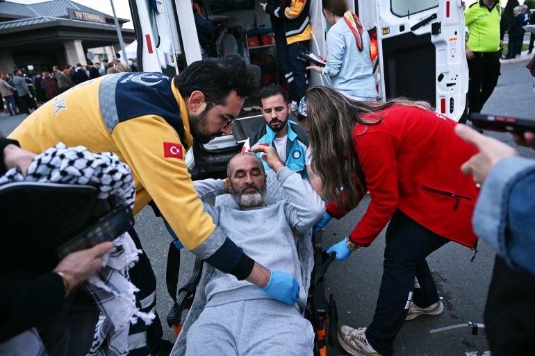 A member of the Global Sumud Flotilla headed for Gaza and arrested and deported by Israel is loaded into an ambulance on a stretcher following the group's arrival at Istanbul Airport on May 21, 2026. The first of hundreds of Gaza flotilla activists began arriving at Istanbul airport on may 21 after being arrested then deported from Israel, an AFP correspondent said. The 422 activists, who were flown from southern Israel on three planes chartered by Ankara, had been part of a fleet of around 50 vessels that set sail from southern Turkey on May 14 seeking to break Israel's blockade on Gaza, which was joined at sea by several others. (Photo by Ozan KOSE / AFP)