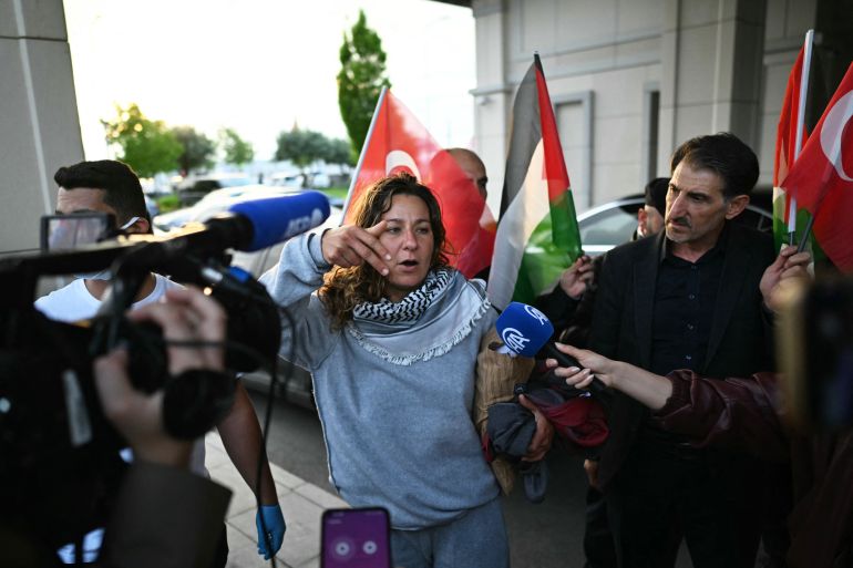 A member of the Global Sumud Flotilla headed for Gaza and arrested and deported by Israel speaks to the press following the group's arrival at Istanbul Airport on May 21, 2026. The first of hundreds of Gaza flotilla activists began arriving at Istanbul airport on may 21 after being arrested then deported from Israel, an AFP correspondent said. The 422 activists, who were flown from southern Israel on three planes chartered by Ankara, had been part of a fleet of around 50 vessels that set sail from southern Turkey on May 14 seeking to break Israel's blockade on Gaza, which was joined at sea by several others. (Photo by Ozan KOSE / AFP)