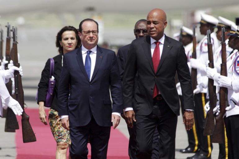 French President Francois Hollande (L) and Haiti's President Michel Martelly (R) are accompanied by Haiti's Prime Minister Evans Paul (back R) and Haiti's French Ambassador Elisabeth Beton-Delegue as they attend an official welcoming ceremony at Toussaint Louverture international airport in Port-au-Prince, May 12, 2015. REUTERS/Andres Martinez Casares