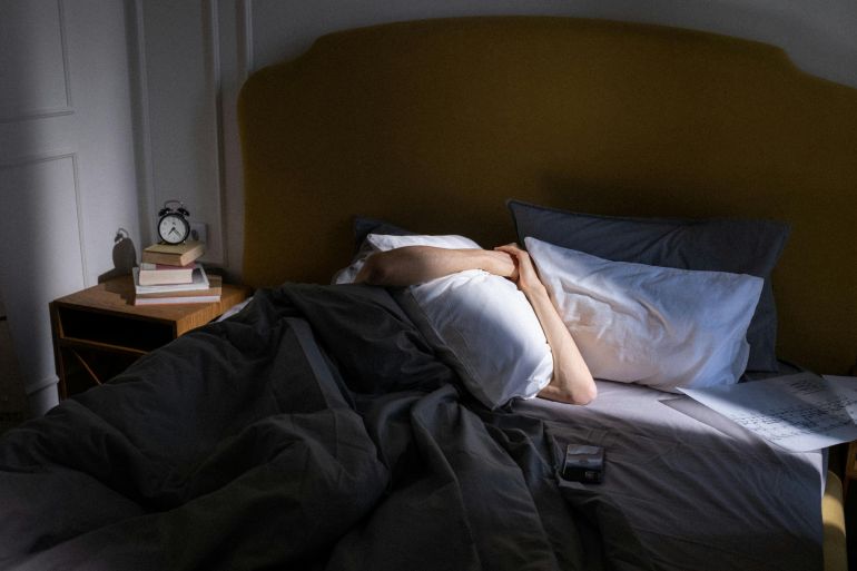 A peaceful bedroom setting with a person resting under sunlight, capturing a serene early morning vibe.