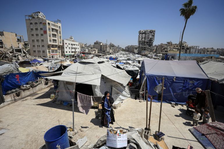 A displaced Palestinian woman stands among tents at a camp for displaced people in Gaza City, April 28, 2026. REUTERS/Dawoud Abu Alkas