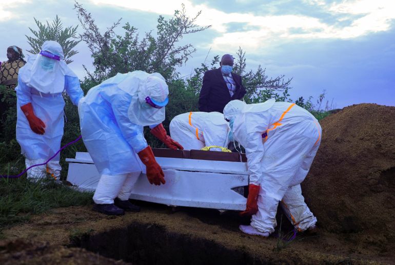 Congolese medical workers wearing personal protective equipment (PPE) prepare to bury the coffin of a patient who died of Ebola, as authorities intensify efforts to contain a new Ebola outbreak involving the Bundibugyo strain outbreak in Rwampara outside Bunia, Ituri province, Democratic Republic of Congo, May 21, 2026. REUTERS/Stringer