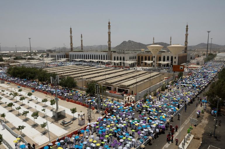 Muslim pilgrims use umbrellas to shield themselves from the sun after noon prayers outside Nimrah Mosque at the Plain of Arafat during the annual hajj pilgrimage, outside the holy city of Mecca, Saudi Arabia, May 26, 2026. REUTERS/Ibraheem Abu Mustafa REFILE - QUALITY REPEAT