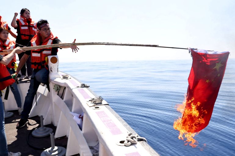rtsbomje Members of the pro-independence Taiwan Statebuilding Party burn a Chinese flag on boat trip in the Taiwan Strait, in Kaohsiung