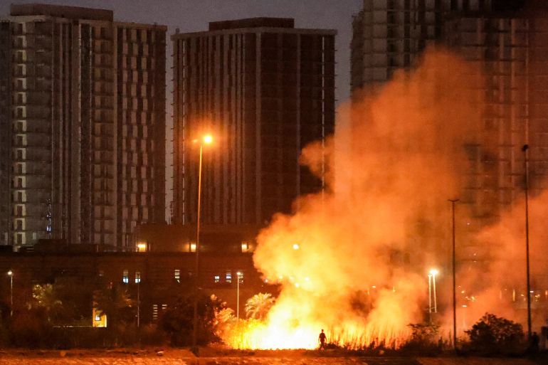 A fire burns outside the grounds of the US Embassy headquarters in Baghdad's fortified "Green Zone" on March 17, 2026 following a drone and rocket attack according to security officials. The strikes came hours after air defences thwarted a rocket attack at the embassy and a drone sparked a fire at a luxury hotel frequented by foreign diplomats in the Green Zone. Iraq was drawn into the Middle East war after having long been a proxy battleground between the US and Iran, with strikes targeting Iran-backed groups that have claimed daily attacks on US interests in Iraq and across the region. (Photo by AHMAD AL-RUBAYE / AFP) / The erroneous mention[s] appearing in the metadata of this photo by AHMAD AL-RUBAYE has been modified in AFP systems in the following manner: [outside the grounds] instead of [on the grounds]. Please immediately remove the erroneous mention[s] from all your online services and delete it (them) from your servers. If you have been authorized by AFP to distribute it (them) to third parties, please ensure that the same actions are carried out by them. Failure to promptly comply with these instructions will entail liability on your part for any continued or post notification usage. Therefore we thank you very much for all your attention and prompt action. We are sorry for the inconvenience this notification may cause and remain at your disposal for any further information you may require.