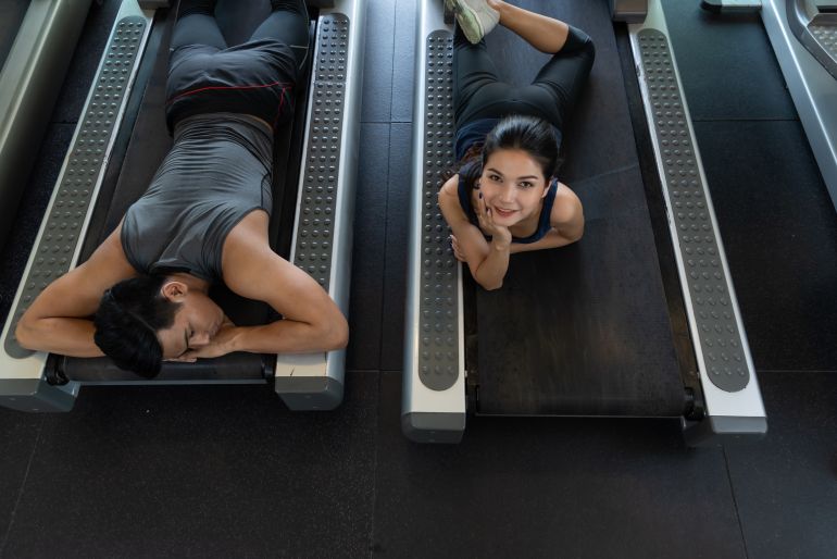 In the fitness,man and woman exercise on training equipmet,tried and relax on equipment in gym.