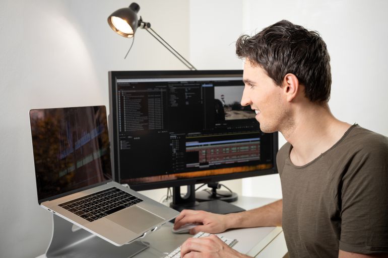 this content creator is a professional video editor who cuts and edits an online video on his desk with his computer