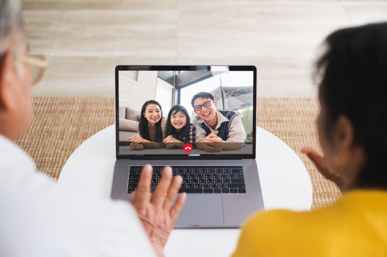 Asian old senior couple video call virtual meeting via computer laptop with family