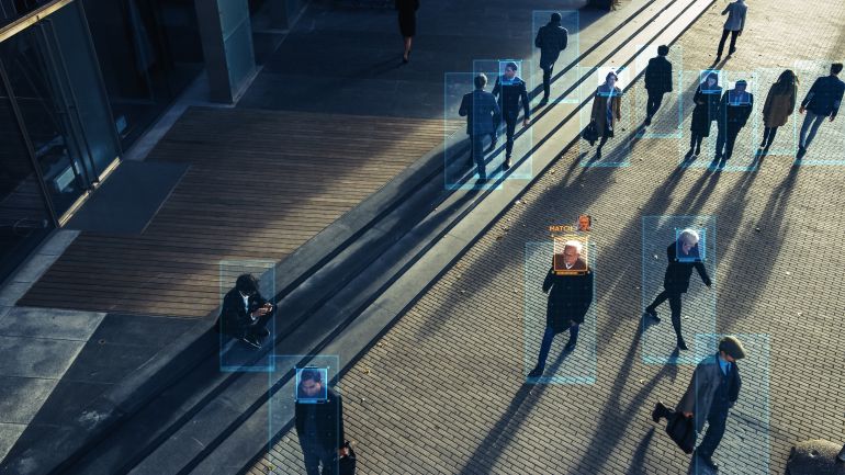 CCTV AI Facial Recognition Camera Zoom in Recognizes Person. Elevated Security Camera Surveillance Footage Face Scanning of a Crowd of People Walking on Busy Urban City Streets. Big Data Analysis
