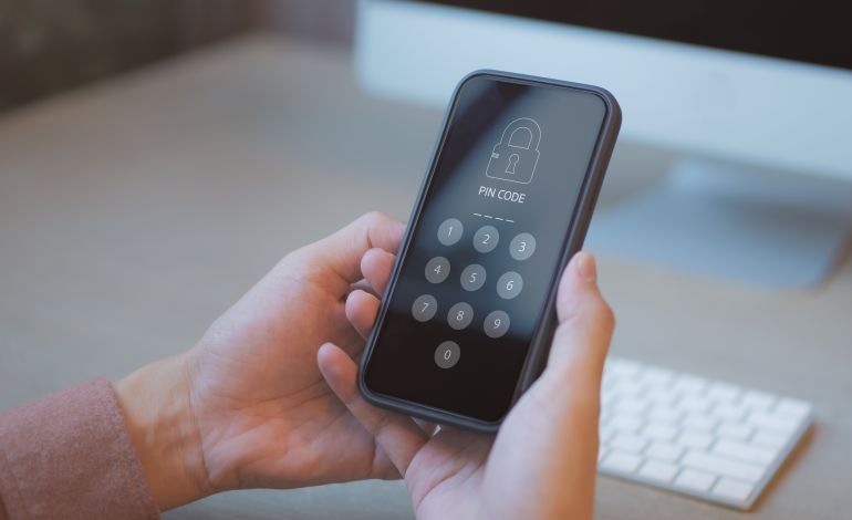 shutterstock_2234355059-1779875359 Device secure access concept, Businessman accessing smartphone with pin code. cyber security, hacking phishing, Mobile phone password to access smartphone, security threats online, privacy lock screen
