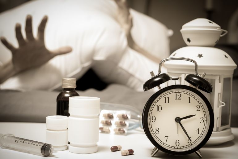 man in bed want tablets and drugs suffering insomnia, hangover, headache at night