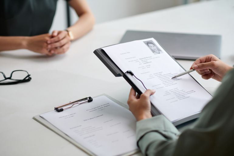 HR manager reading cv of applicant in job interview