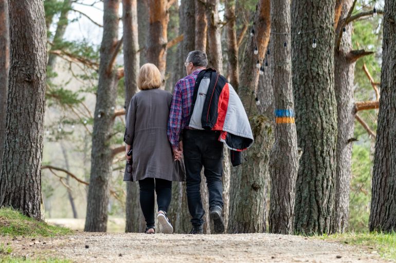 shutterstock_2447936799-1778411209 Midlife Couple Holding Hands Strolling Through Forest Path: Love's Journey. Romantic Forest Walk: Middle-aged Couple Hand in Hand.