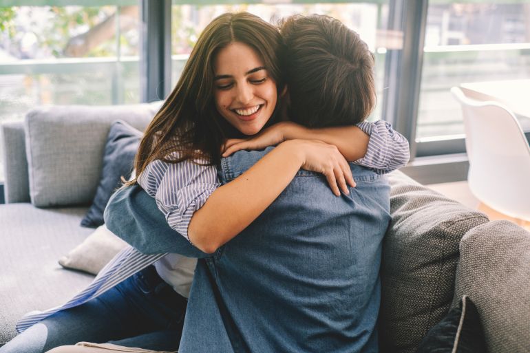 shutterstock_2485968701-1778238556 Beautiful young couple hugging in their new apartment. Engaged couples celebrate by hugging each other happily for their new home.
