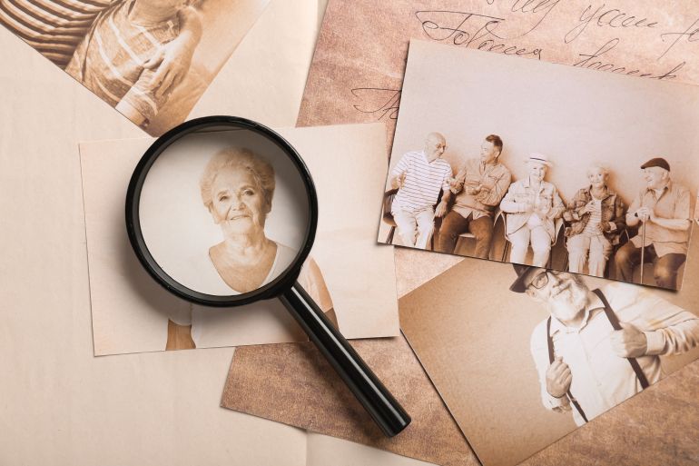 shutterstock_2605530907-1779709274 Hand of woman creating family tree with old photos of relatives