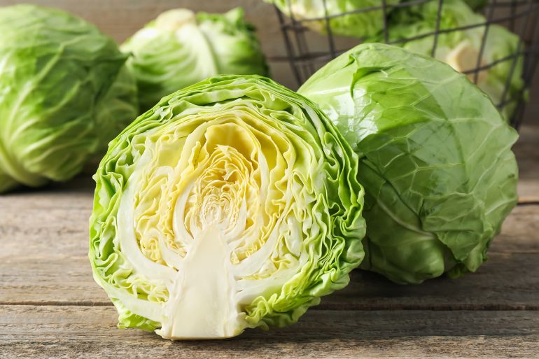 Fresh cabbages and basket on wooden table, closeup; Shutterstock ID 2640169105; purchase_order: aj; job: ; client: ; other: