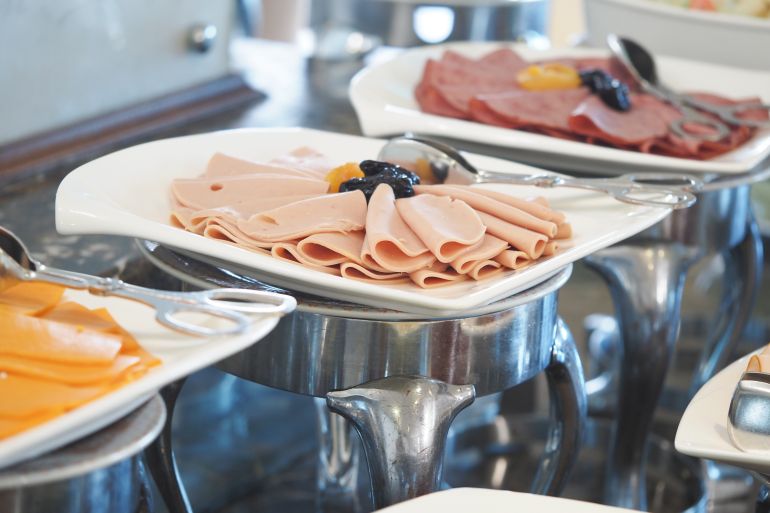 Sliced deli meats displayed at a buffet setting