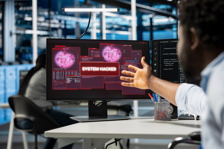 Close up of computer scientist in server hub asking coworker for help, trying to protect equipment from hacker. IT specialist in data center facility requesting assistance to fix security breach alert