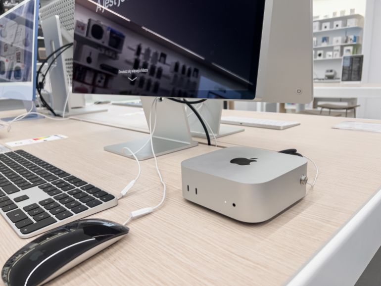 Poznan, Poland - September 20, 2025: An Apple Mac Mini computer, Magic Keyboard, and Magic Mouse are positioned on a clean wooden desk, showcasing new technology
