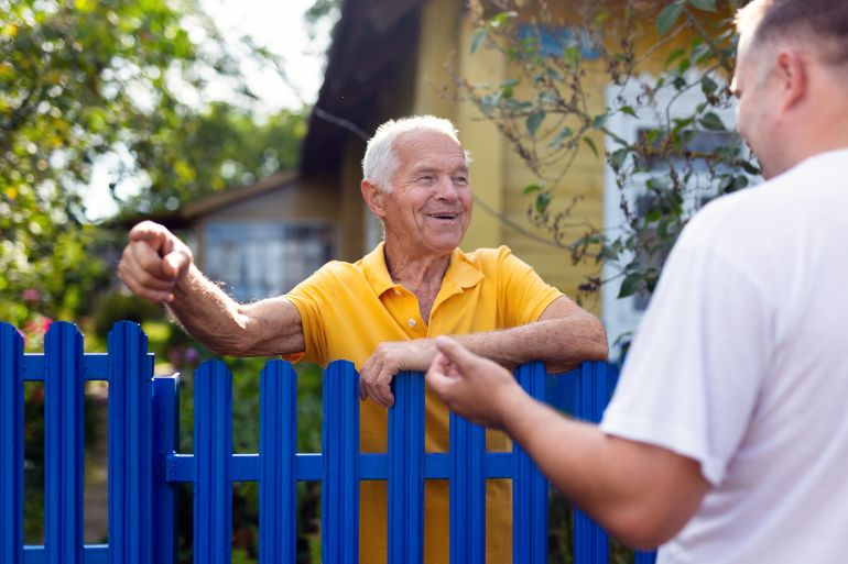 shutterstock_2697752855-1780044137 Neighbor conversation. Two smiling men breezily chatting