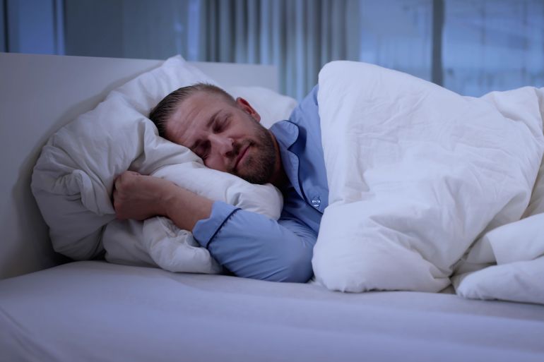 Beautiful Blonde Man Sleeping Peacefully On White Hotel Pillow