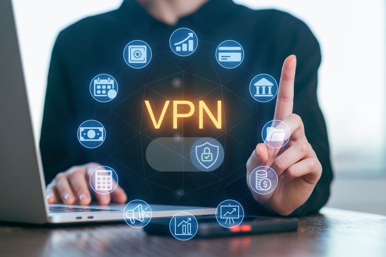 A person seated at a desk uses a laptop to explore various VPN features.