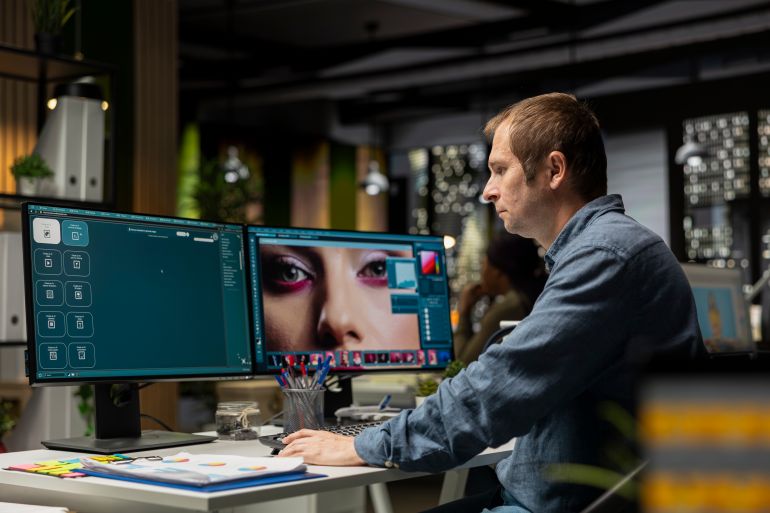 Male skilled editor using AI chatbot turning text prompt into photos and retouching, adjusting color to ensure professional content for clients. AI powered image editing, creative industry.