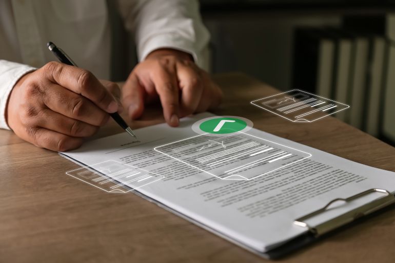 shutterstock_2740687667-1779100276 Business professional signing contract document with digital approval and verification concept on office desk representing online legal agreement process.