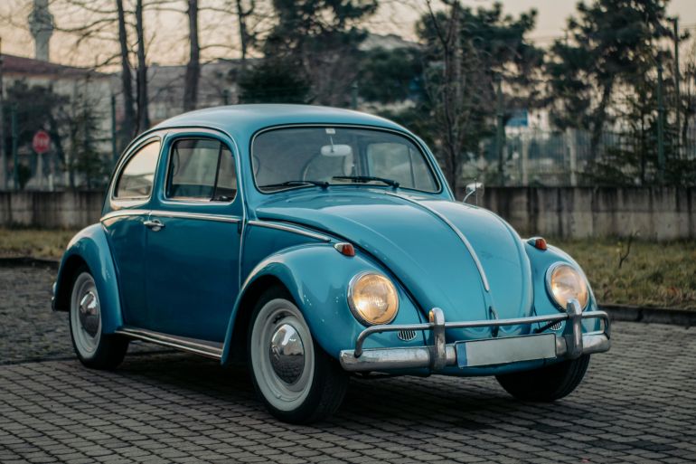 volkswagen-beetle-1778938922 Classic blue Volkswagen Beetle parked outdoors on a cloudy day, showcasing vintage charm.