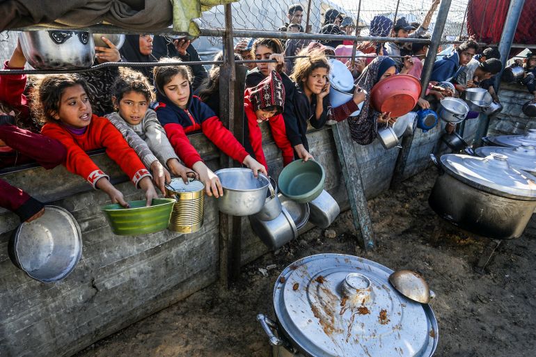 KHAN YUNIS, GAZA - JANUARY 11: Palestinians wait to receive hot meal, distributed by a charity organization, as the food crisis continues due to limited humanitarian aid in al-Mawasi region of Khan Yunis, Gaza on January 11, 2026. (Photo by Abed Rahim Khatib/Anadolu via Getty Images)
