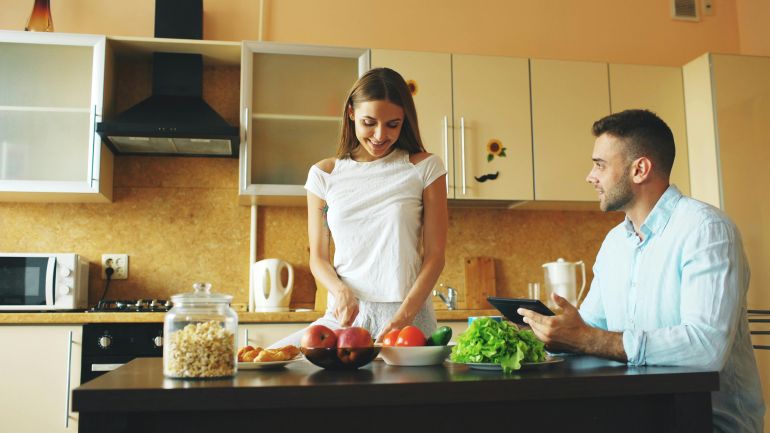 zwjyn-1779347391 A couple enjoying meal preparation with fresh vegetables and fruit in a stylish kitchen.
