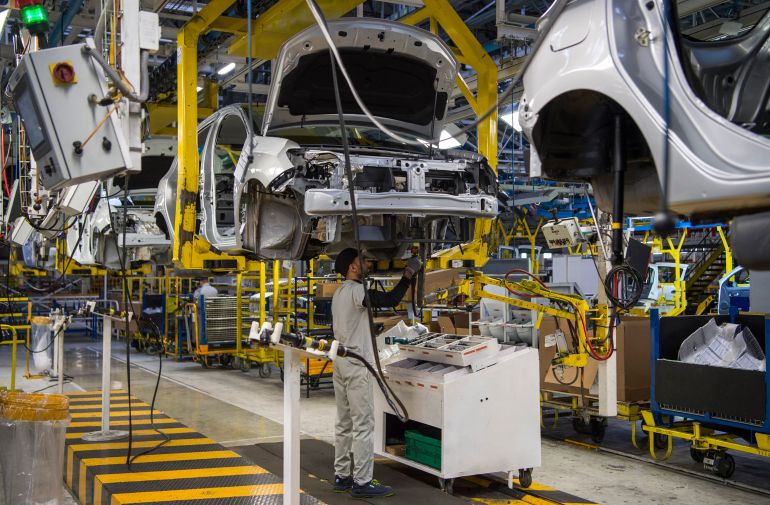 A factory employee works on a car assembly line at the Renault-Nissan Tanger Car Assembly Plant in Melloussa, east of the port city of Tangiers on March 12, 2018. (Photo by FADEL SENNA / AFP)