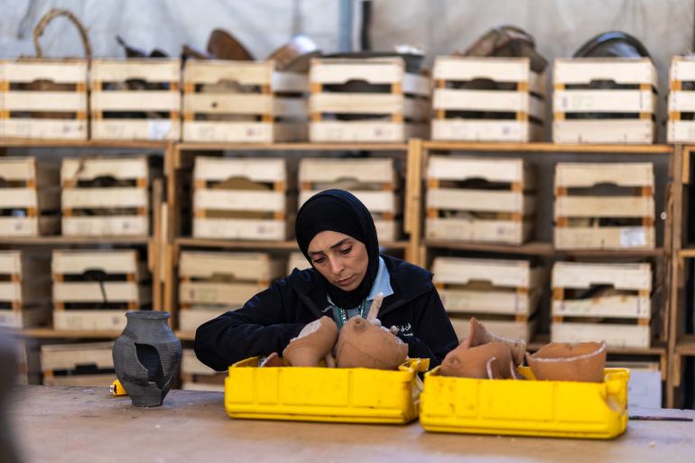 KHAN YUNIS, GAZA, PALESTINE - JUNE 22: A girl works on repairing a clay pot as the “Guardians of Heritage” team continues its work of collecting, documenting, and preserving historical and cultural artifacts belonging to Palestine for future generations, despite ongoing Israeli attacks in Khan Yunis, Gaza, Palestine, on June 22, 2026. ( Mahmoud Abu Hamda - Anadolu Agency )
