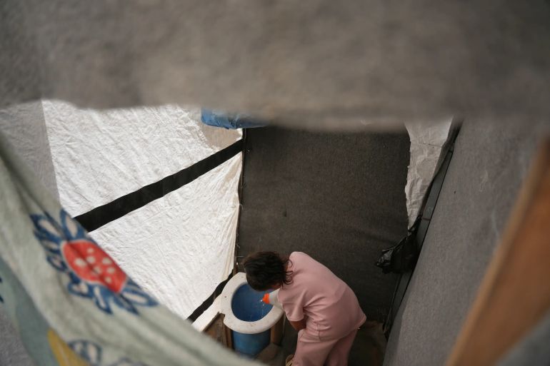Sila Darwish pours water into a makeshift toilet at her family’s tent in Khan Younis, southern Gaza Strip, Wednesday, June 3, 2026. (AP Photo/Abdel Kareem Hana)