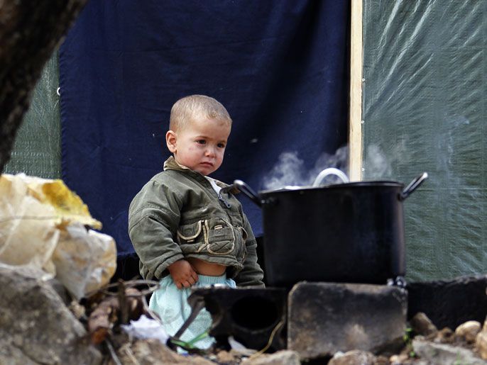 2e48b140-fa48-4f90-a0bb-8aab48396abb epa03966196 A Syrian refugee child stands next to a cooking pan at the Syrian refugee camp in Ketermaya village, near Sidon, southern Lebanon, 26 November 2013. The camp hosts a majority of Syrian refugees from Aleppo and al Ghouta in Rural Damascus all living in makeshift shelters. A group of 'Lahza 2' Project (moment in Arabic) visited the refugees in the camp as part of the project carried in cooperation with the United Nations Children's Fund (UNICEF). The project focuses on children between the age of seven and 12 to let them take photos to illustrate their life as they see through their cameras. EPA/NABIL MOUNZER