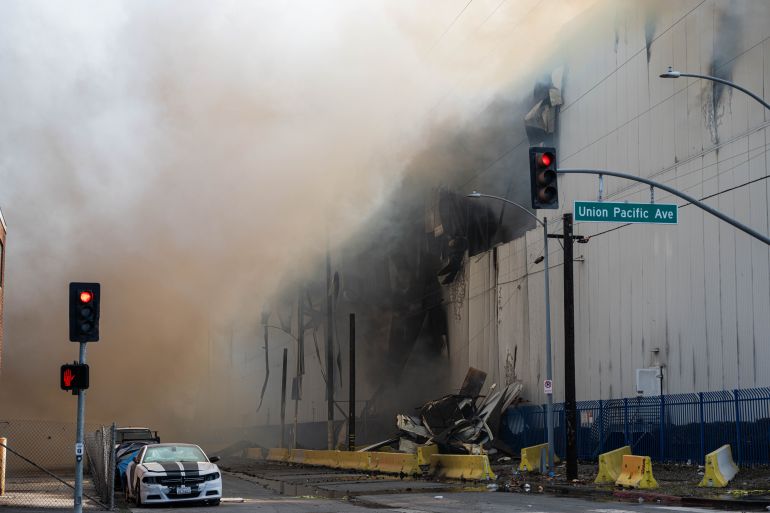 2los-angeles-1782024032 LOS ANGELES, UNITED STATES - JUNE 20: Views of the Burning Lineage warehouse in Boyle Heights, Los Angeles, California, United States, on June 20, 2026. The fire broke out on Thursday at the facility in the Boyle Heights neighborhood near downtown Los Angeles and remained active three days later. Footage showed smoke continuing to rise from the warehouse while firefighting operations and safety measures remained in place around the site. Los Angeles officials have declared a local emergency as efforts to extinguish the fire continue. (Photo by Jon Putman/Anadolu via Getty Images)