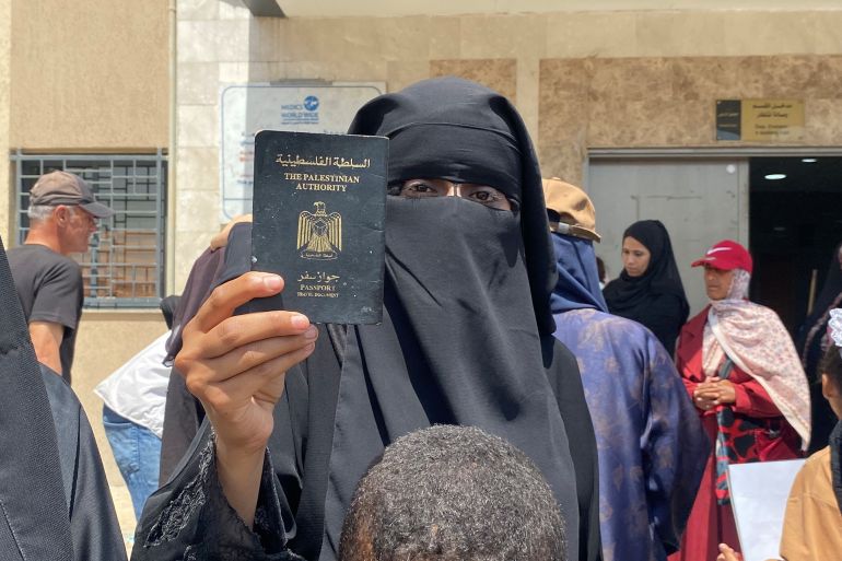 زوجة عالقة ترفع جواز السفر الفلسطيني خلال تظاهرة في مدينة خان يونس جنوب قطاع غزة تطالب برفع الحصار وفتح المعابر