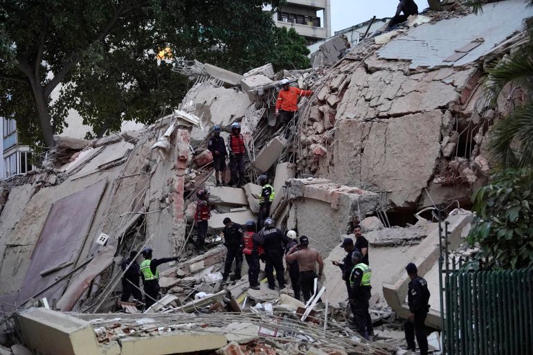 Rescuers search for victims in a collapsed building following an earthquake in Caracas on June 24, 2026. A magnitude 7.1 earthquake struck Venezuela on Wednesday, the United States Geological Survey (USGS) reported, triggering panic in Caracas, according to AFP journalists. The tremor, which was followed by several aftershocks, was also felt in Colombia. (Photo by Manaure Quintero / AFP)