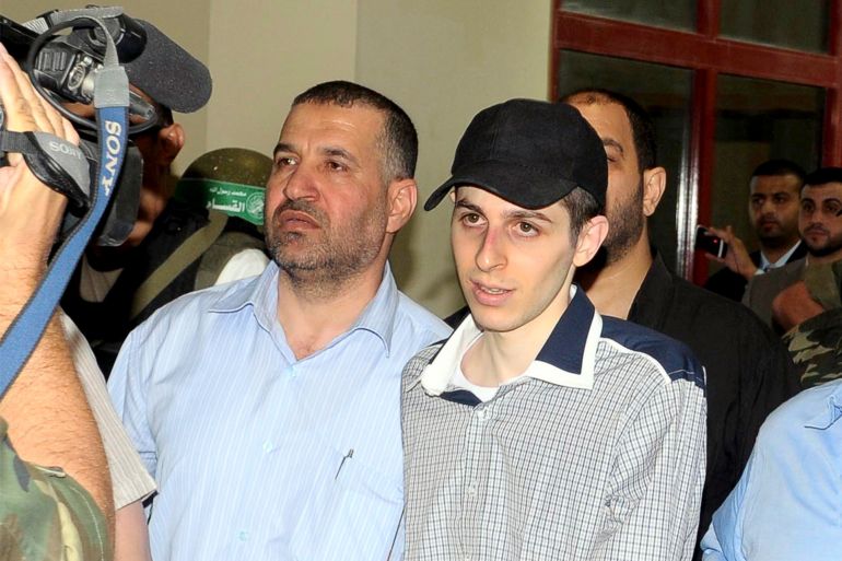 يسار: أحمد الجعبري يمين: جلعاد شاليط Hamas mediator Ahmed Al-Jaabari (L) escorts Israeli soldier Gilad Shalit on the Egyptian side of the Rafah border crossing in this October 18, 2011 file photo. Israel killed Jaabari, the military commander of the Islamist group Hamas, in a missile strike on the Gaza Strip on November 14, 2012 and launched air raids across the enclave, pushing the two sides to the brink of a new war. REUTERS/Middle East News Agency (MENA)/Khalid Farid/File (EGYPT - Tags: POLITICS CIVIL UNREST) FOR EDITORIAL USE ONLY. NOT FOR SALE FOR MARKETING OR ADVERTISING CAMPAIGNS. THIS IMAGE HAS BEEN SUPPLIED BY A THIRD PARTY. IT IS DISTRIBUTED, BY REUTERS, AS A SERVICE TO CLIENTS