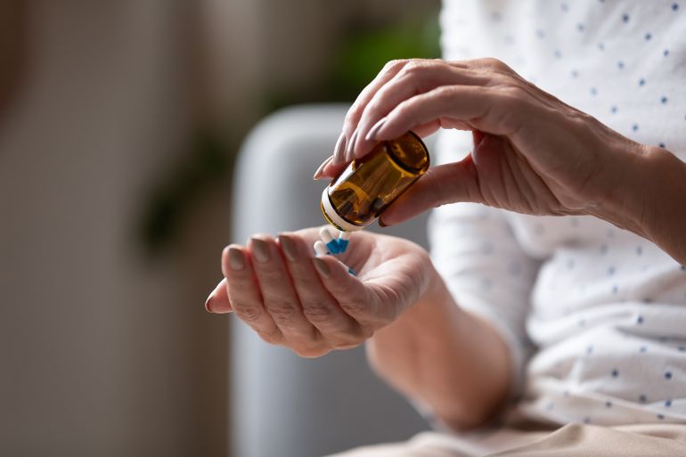 Close up mature woman taking out pills from bottle, supplements or antibiotic, older female preparing to take emergency medicine, chronic disease, healthcare and treatment concept