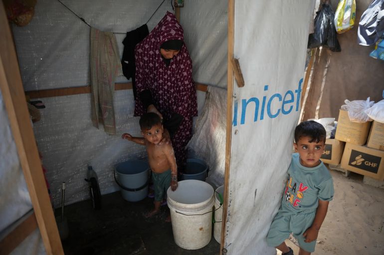 Iman Mansour bathes her son, Mohamed Shaban, in a makeshift bathroom beside her family’s tent in Khan Younis, southern Gaza Strip, Wednesday, June 3, 2026. (AP Photo/Abdel Kareem Hana)
