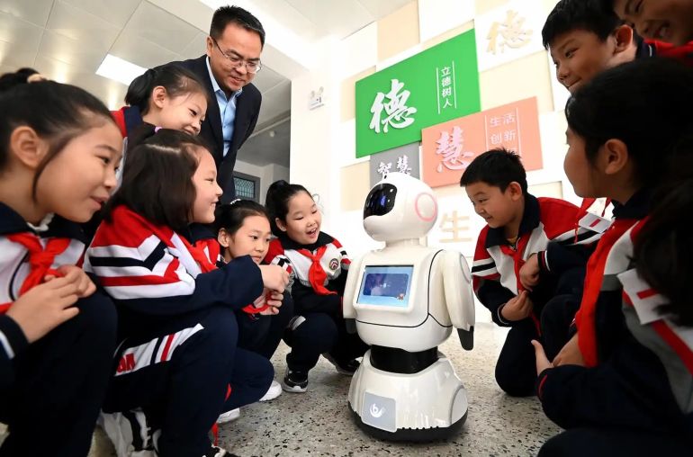 Primary school students talk and interact with a robot in Handan, China, on October 29, 2024. (Photo by Costfoto/NurPhoto via Getty Images)
