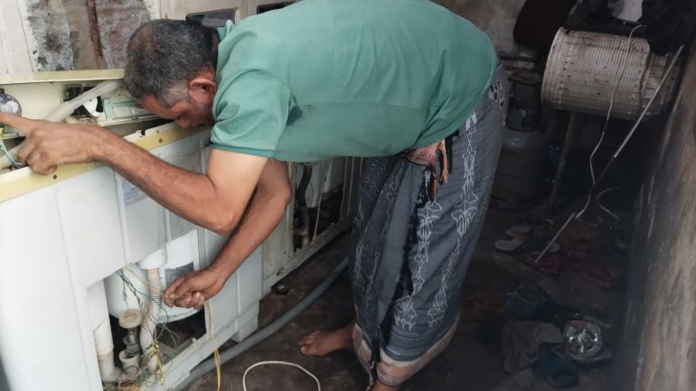 6543-11-1780909838 لطفي يفحص أسلاكا كهربائية مستعينًا بخبرة السنين (الجزيرة)