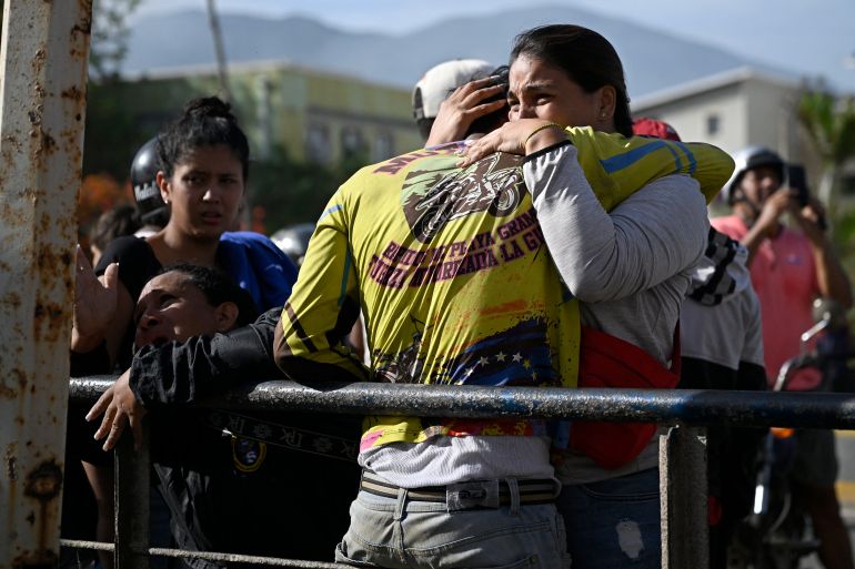 People react near a damaged apartment building following an earthquake in Catia La Mar, La Guaira state, about 30 km northwest of Caracas, on June 25, 2026, as they mourn the death of a relative. A twin earthquake that was Venezuela's largest in over a century has killed at least 164 people and destroyed multiple buildings near the capital, where residents searched on June 25 for missing relatives. (Photo by Federico PARRA / AFP)