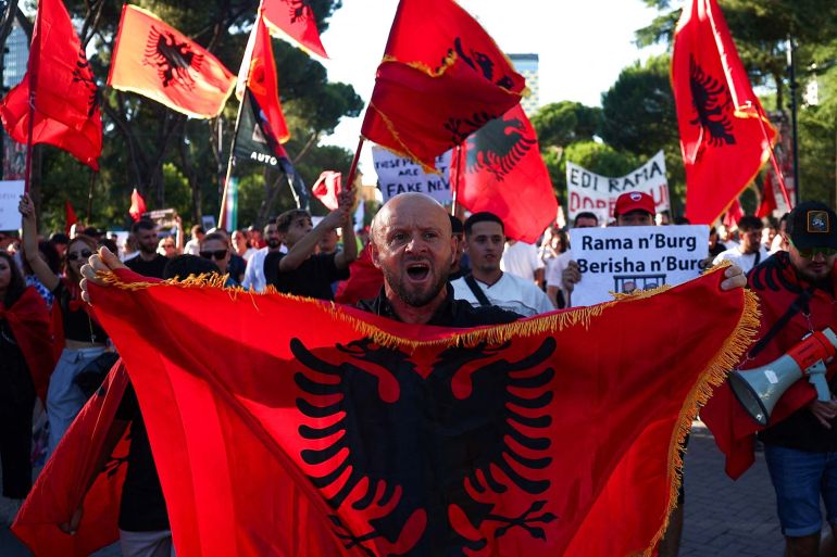 A protester holds an Albanian flag as he shouts slogans during a protest against a luxury resort plan by a company linked to Donald Trump's son-in-law, Jared Kushner, on an environmentally sensitive part of the Adriatic coast, in Tirana, Albania, June 5, 2026. REUTERS/Florion Goga
