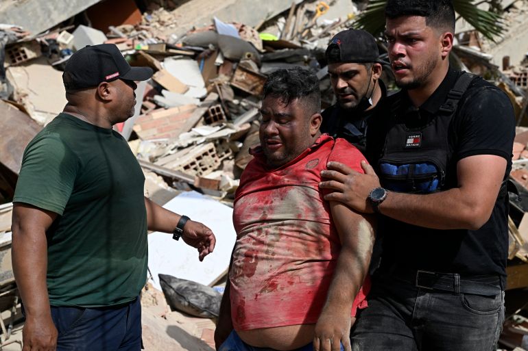 Volunteers help a man found amid the rubble following a twin earthquake in Caraballeda, La Guaira state, about 40 km northeast of Caracas, on June 25, 2026. The death toll from twin quakes, measured at magnitudes 7.2 and 7.5, has risen to at least 188, with more than 1,520 others injured, top lawmaker Jorge Rodriguez reported, while residents continue searching for missing relatives. (Photo by Federico PARRA / AFP)