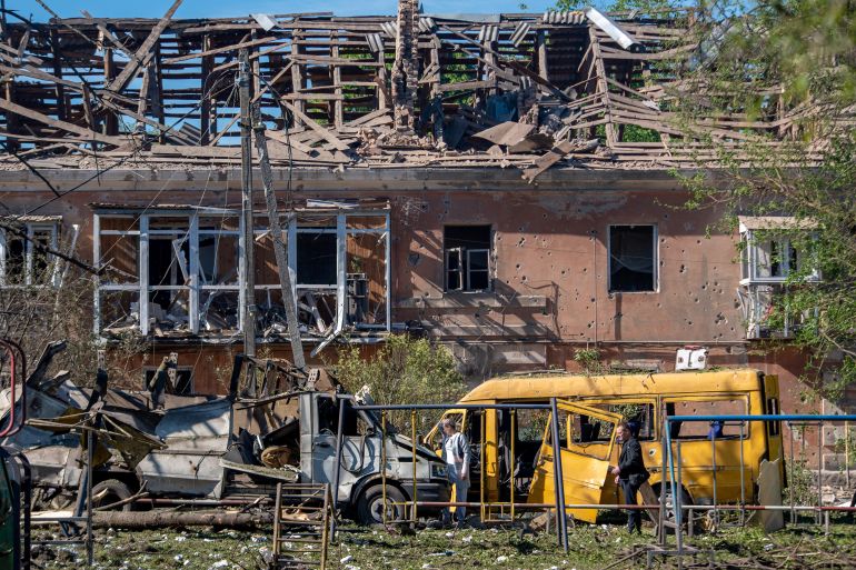 Local residents inspect destroyed cars in front of a heavily damaged building following an air attack in Dnipro on June 2, 2026, amid the Russian invasion of Ukraine.