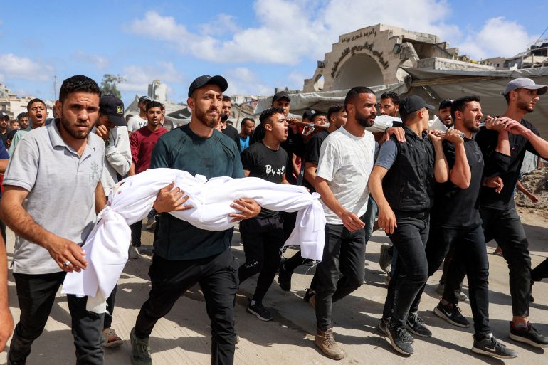 afp_6a254674cd79-1780827764-1 EDITORS NOTE: Graphic content / A mourner carries the body of five-year-old Palestinian Maryam Qaddoum, who was killed along with her father Abdullah Qaddoum the previous day following Israeli bombardment on the Rimal shelter for people displaced by war, during their funeral as they walk past the former headquarters of the Palestinian Legislative Council in Gaza City on June 7, 2026.